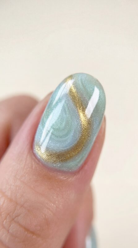 Uña con diseño ojo de gato en azul y dorado